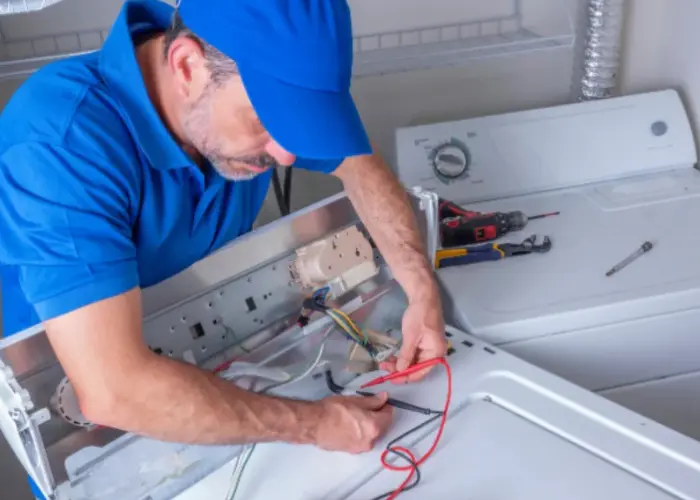 Técnico especialista de Solution Part realizando un diagnóstico eléctrico en una secadora de ropa.