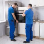 Técnicos de Solution part en pleno proceso de instalación de un horno empotrado en una cocina de cliente...