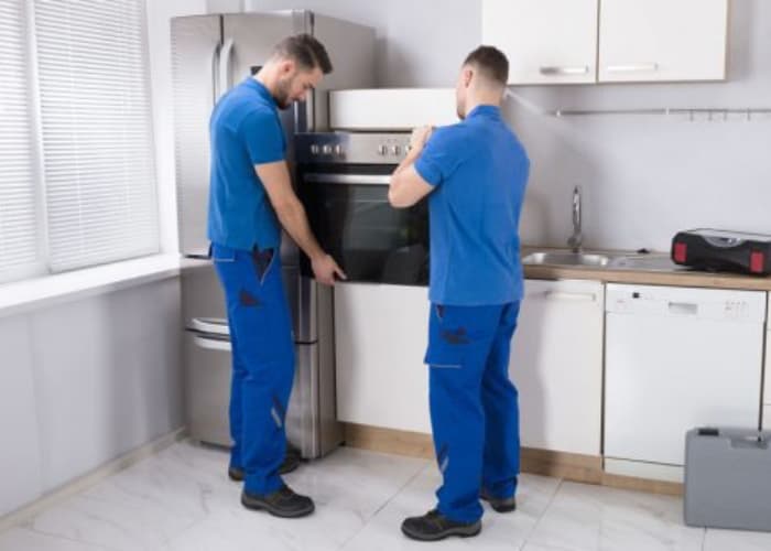 Técnicos de Solution part en pleno proceso de instalación de un horno empotrado en una cocina de cliente...