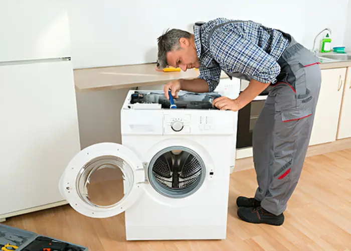 Técnico experto de Solution Part realizando la reparación interna de una lavadora a domicilio..