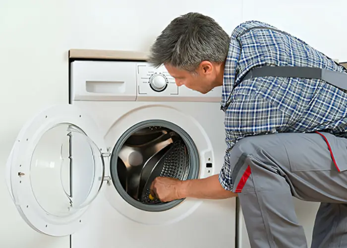 Técnico realizando reparación de lavadora en domicilio, servicio disponible en Viña del Mar, Reñaca y Concón.