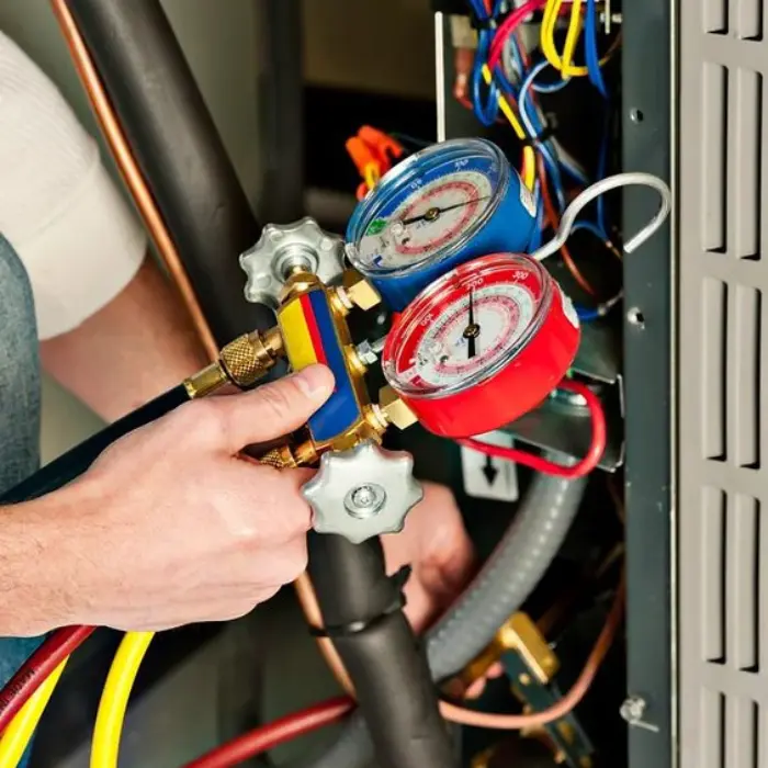 Primer plano de un técnico de Solution Part usando un manómetro para medir la presión del gas refrigerante durante el mantenimiento de un equipo.
