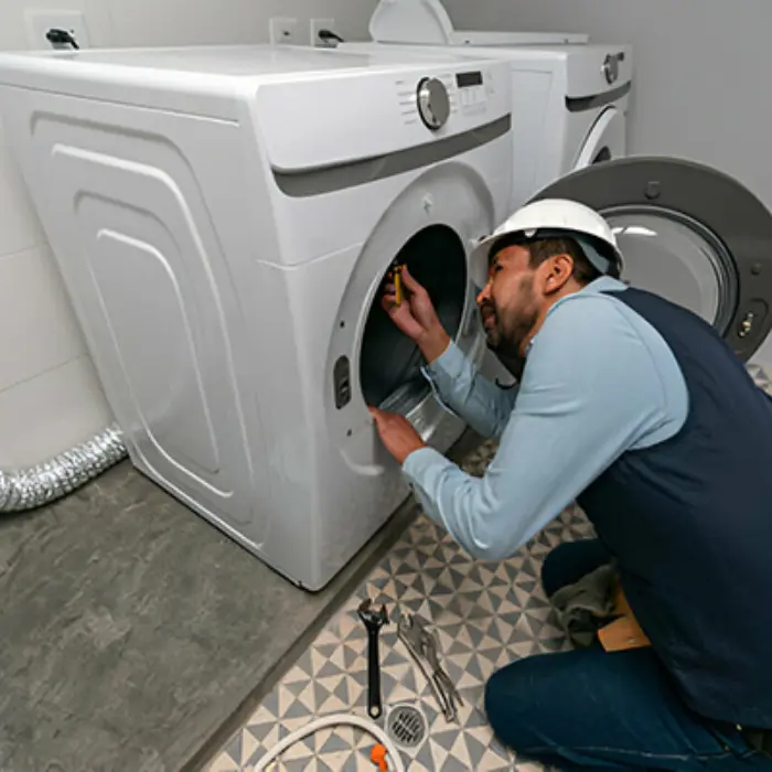 Técnico profesional de Solution Part con casco, inspeccionando el interior de una lavadora de carga frontal durante un servicio a domicilio.